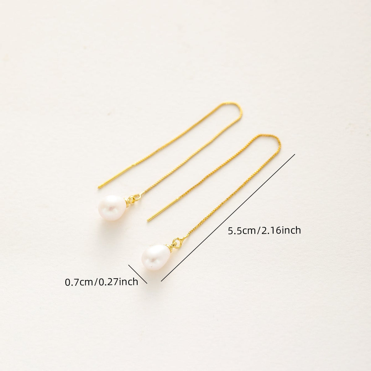 Gold chain earrings with a single white pearl drop