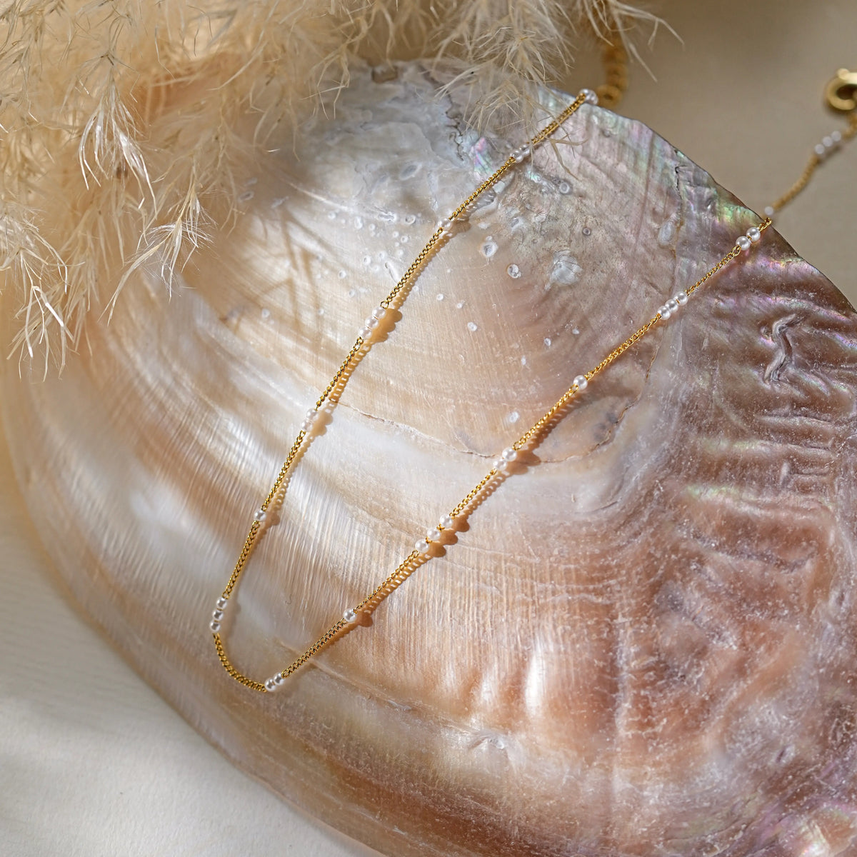 A dainty gold necklace with tiny pearls