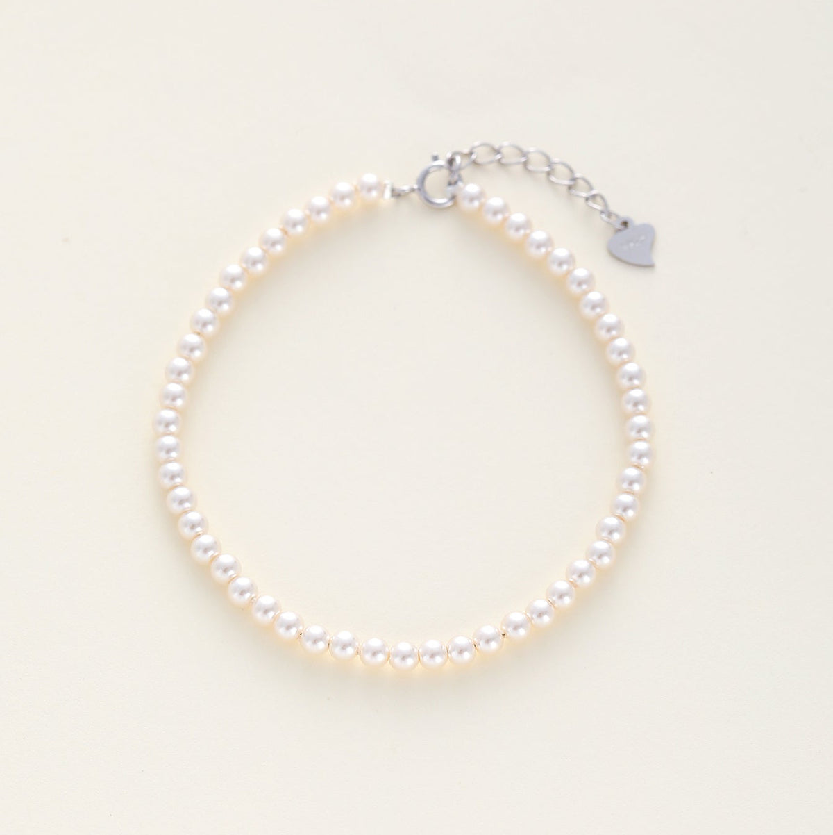 A minimalist bridal pearl beaded bracelet with a silver lobster clasp and an adjustable silver chain extender