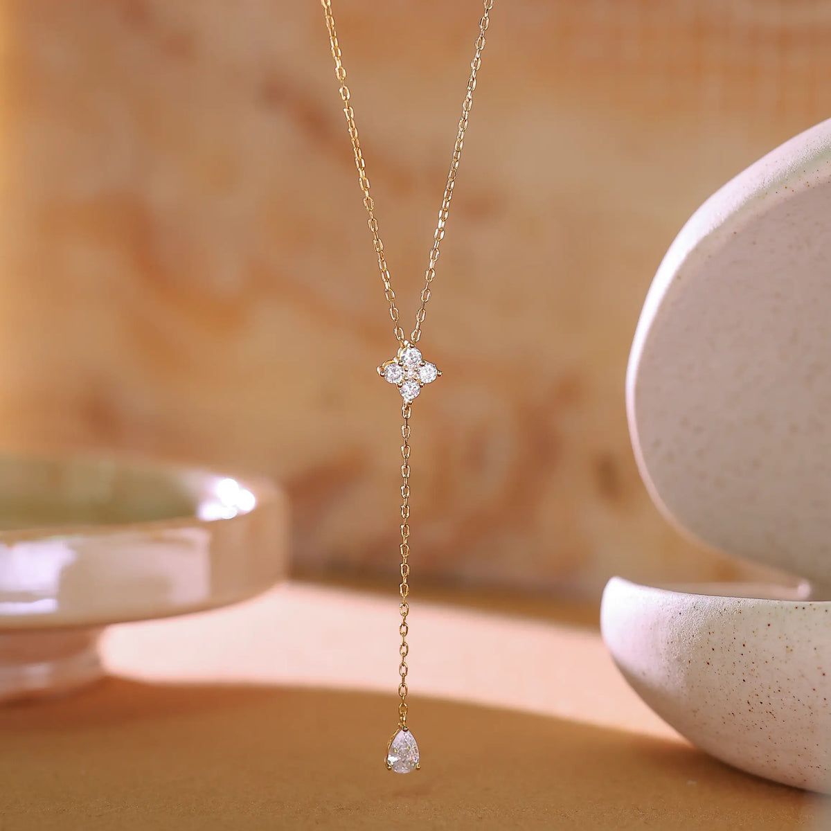 Macro shot of cubic zirconia flower cluster setting on gold lariat necklace