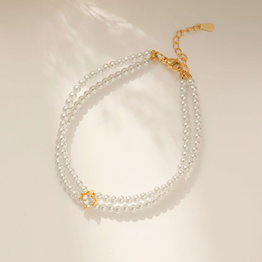 A gold double-strand pearl necklace with cz placed in the middle with extender chain