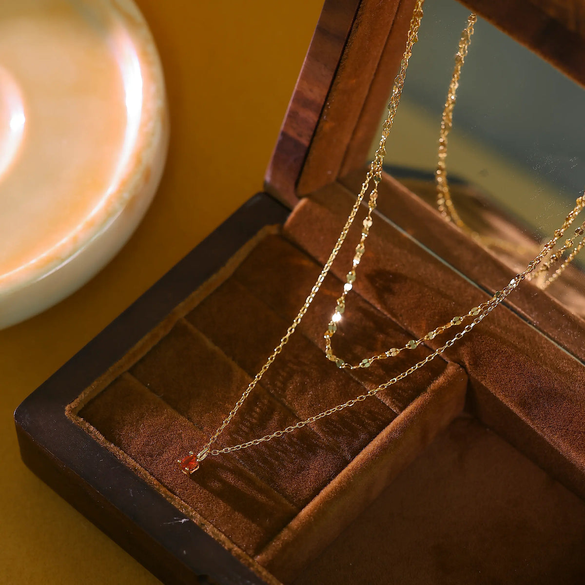 Gold layered necklace laid flat on white background showing 40cm and 45cm chain lengths.