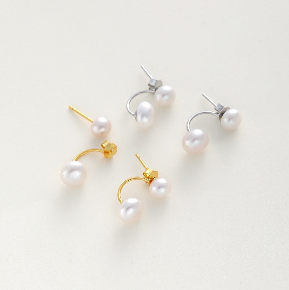 2 in 1 double pearl stud earrings with curved gold and silver metal settings.