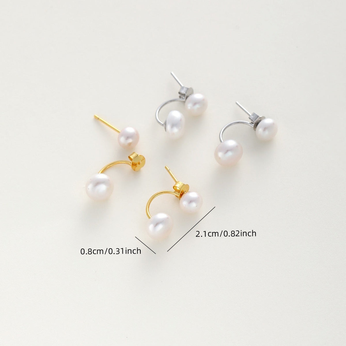 Gold and silver ear jacket earrings with white pearl drops, displayed on a light beige background with dimension markings showing 0.8cm (0.