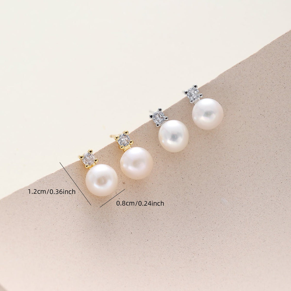 CZ pearl stud earrings with small clear stones in gold and silver settings, displayed on a beige curved surface with size measurements shown.