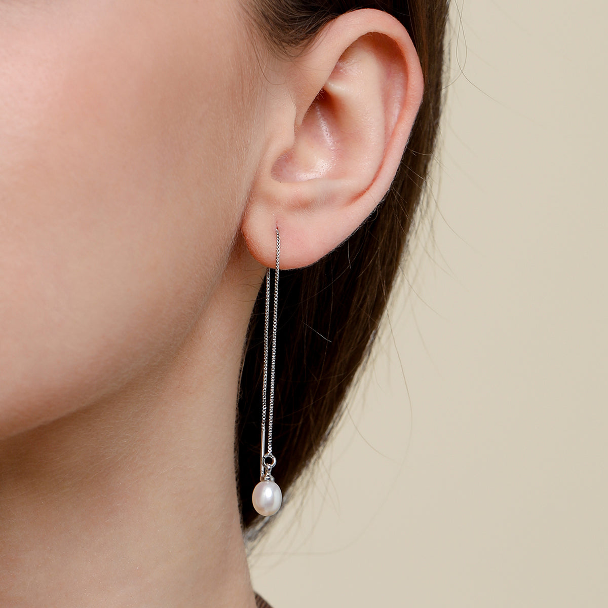 close up of model wearing minimalist silver pearl threader earrings