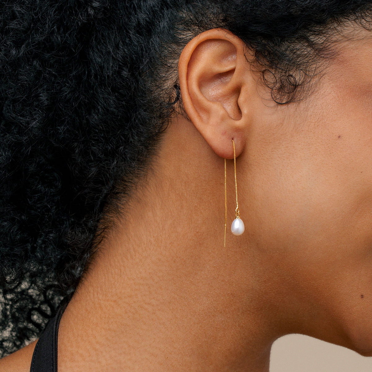 close up of model wearing 18K gold chain teardrop pearl earrings