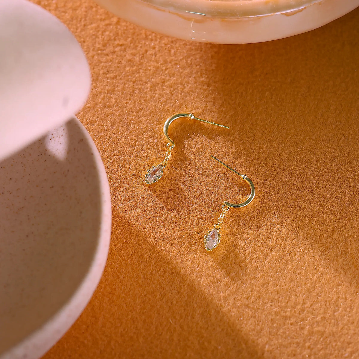 Pair of gold drop earrings laid flat next to a ruler showing 25mm length.