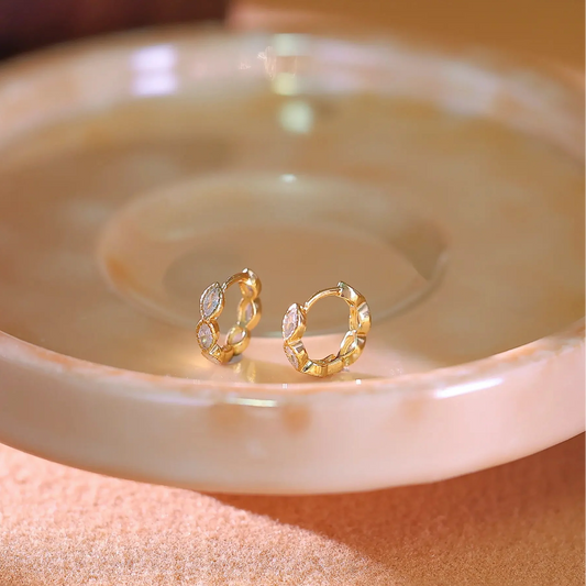 14K gold plated hoop earrings set with marquise cubic zirconia stones along the band.