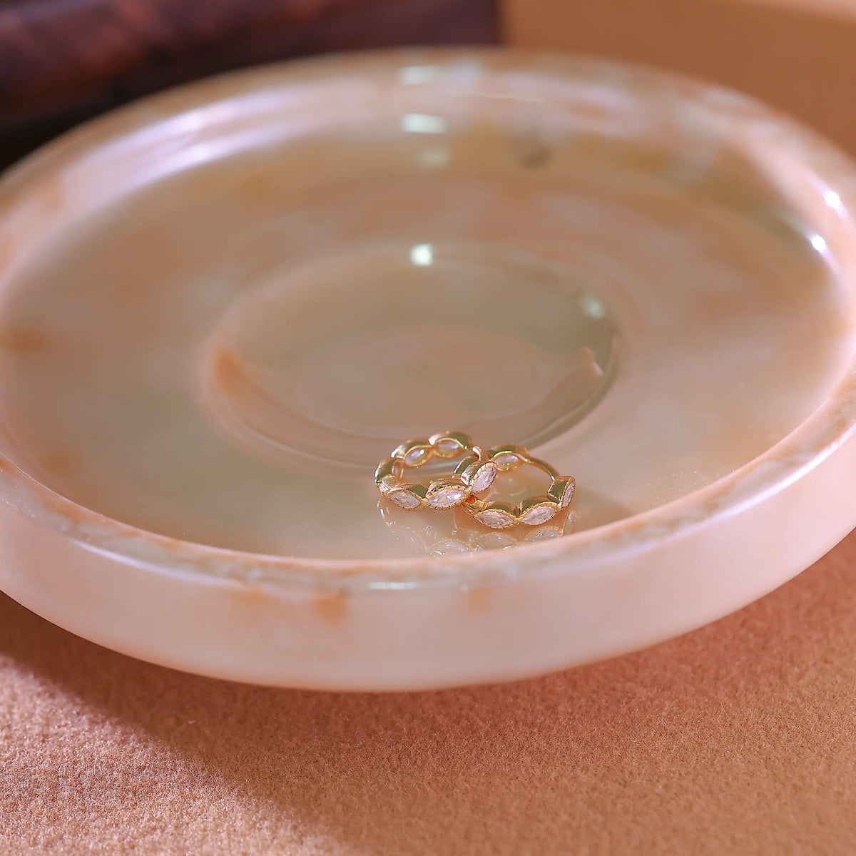 Macro shot of the prong-set marquise stones curving around the gold hoop earring.