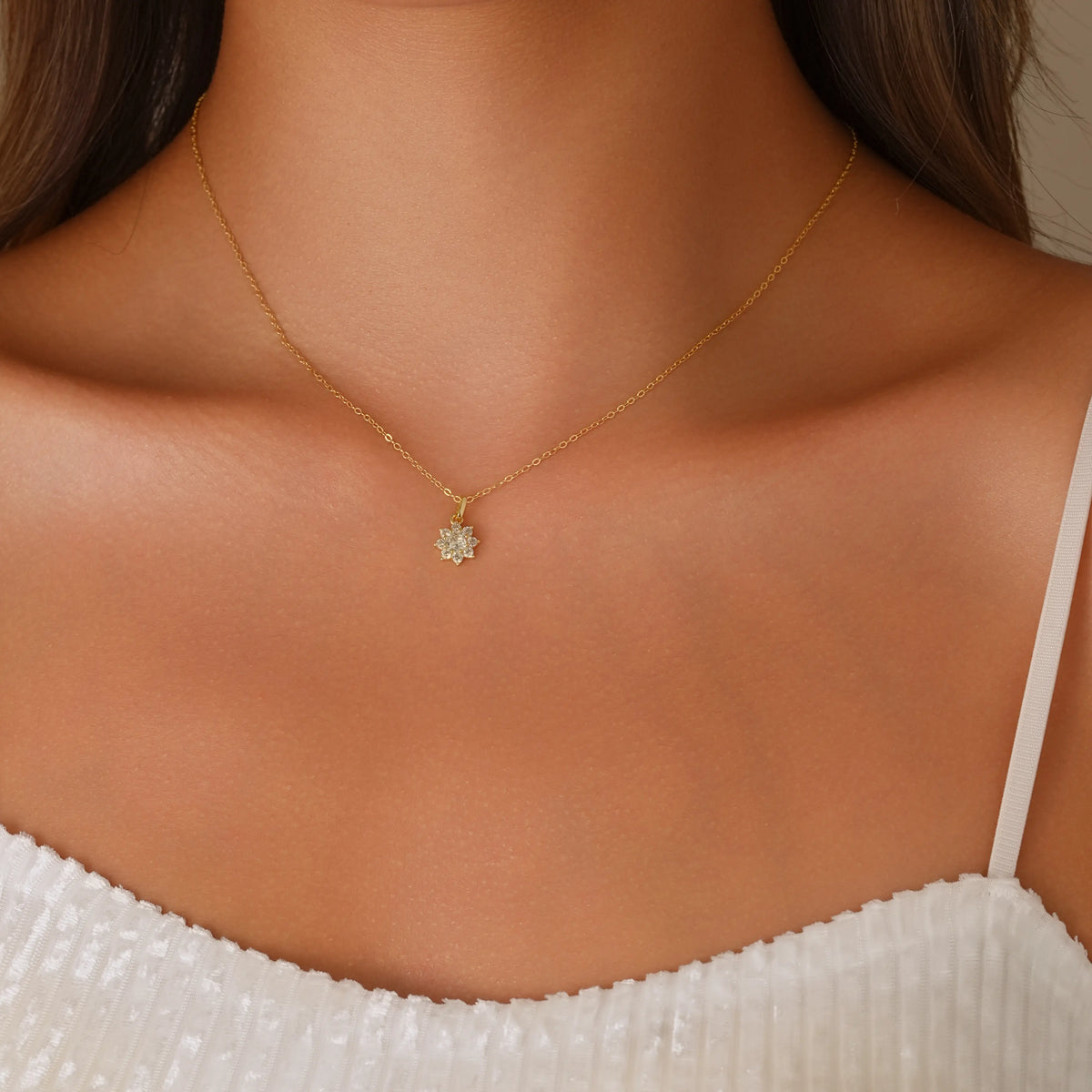 Close-up of a gold pave snowflake necklace on a model, showing the adjustable 42cm chain length.