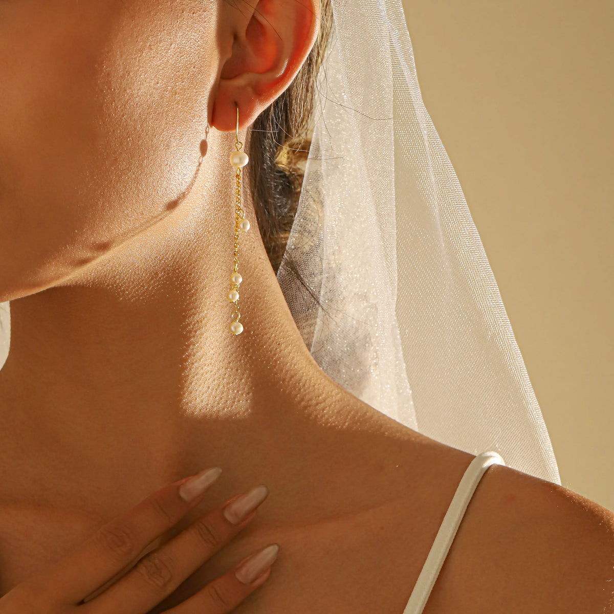 close up of a bride wearing statement long dangle pearl tassel earrings