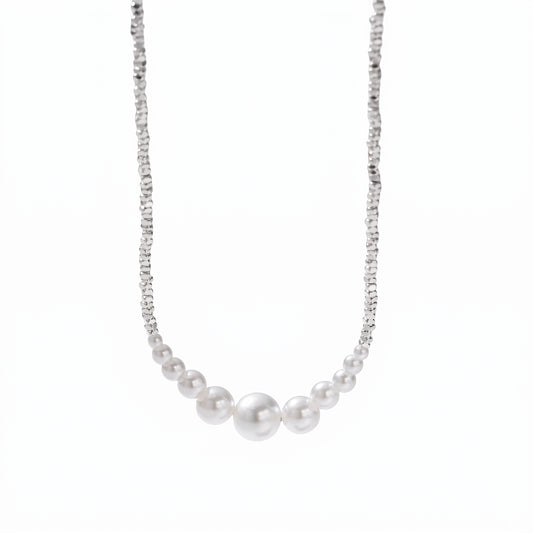 Minimalist round pearl bead necklace resting on a fine silver chain.