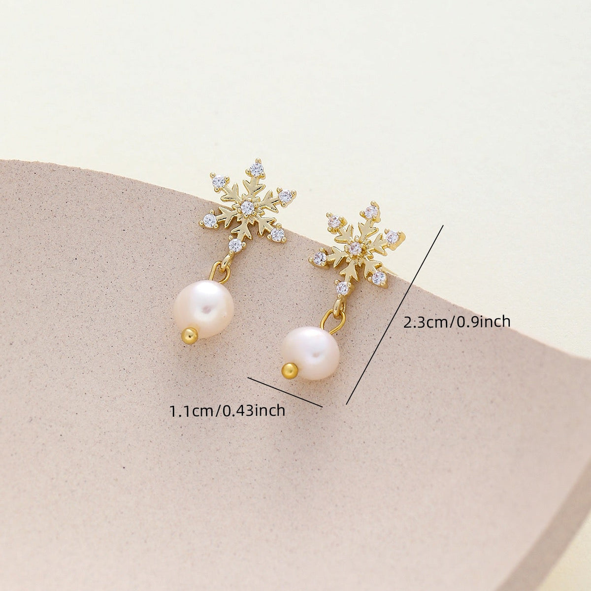 Gold snowflake dangle earrings with white pearls and clear cz