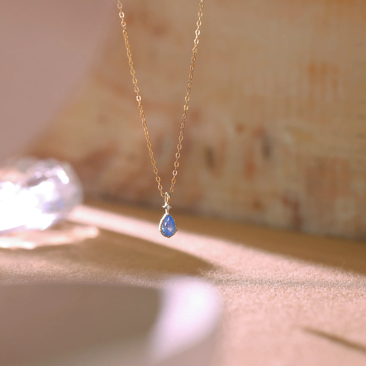 Macro shot of the icy blue cubic zirconia stone in a teardrop gold setting.