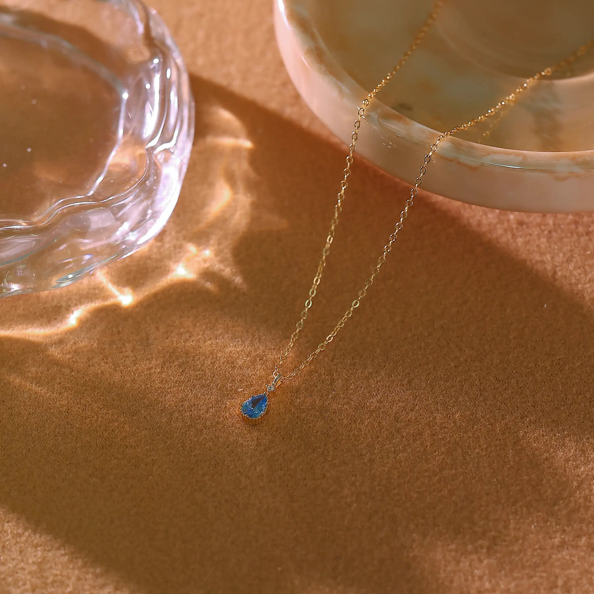 Blue topaz gold necklace laid flat on a white background showing full 42cm length