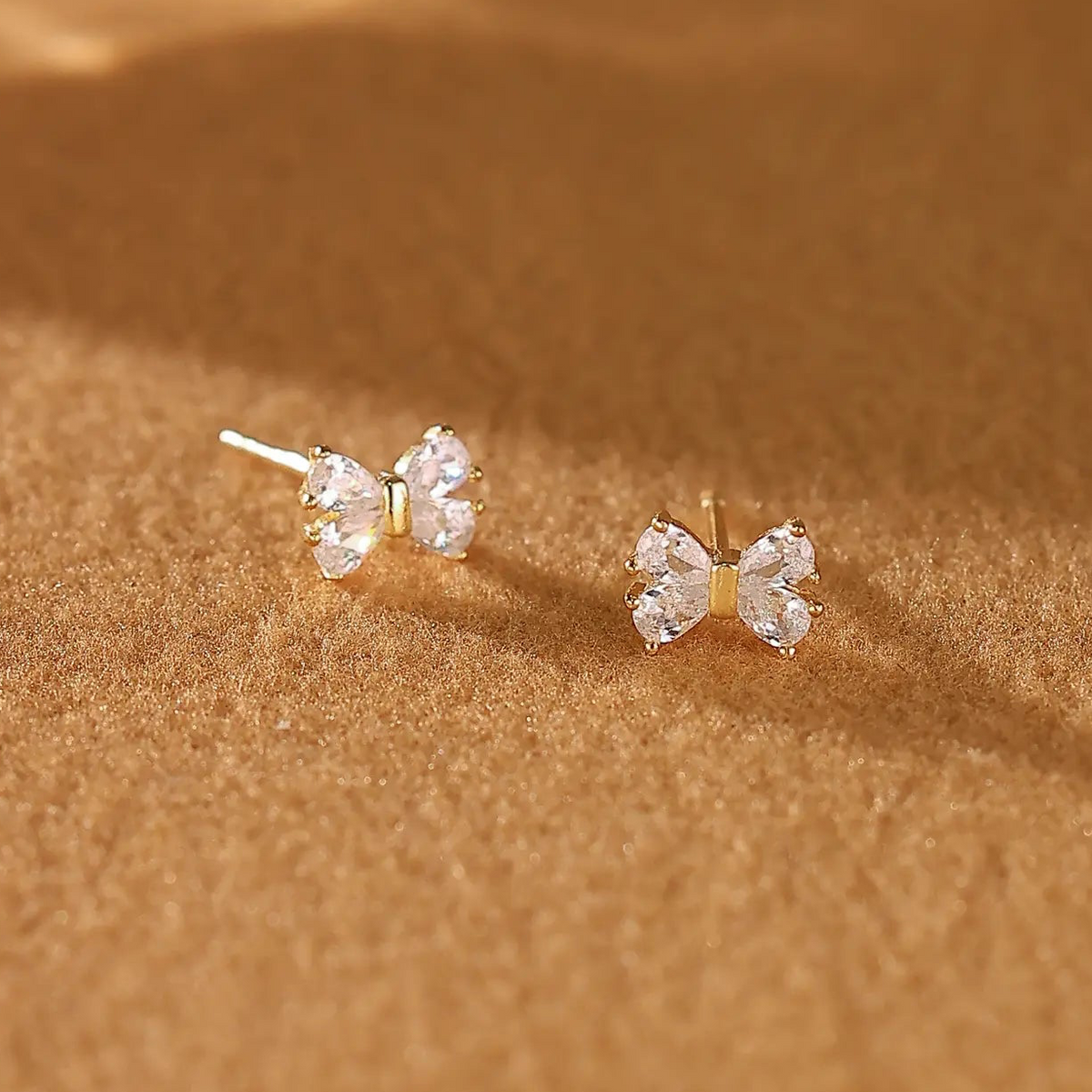 A pair of dainty 925 sterling silver gold bow stud earrings 