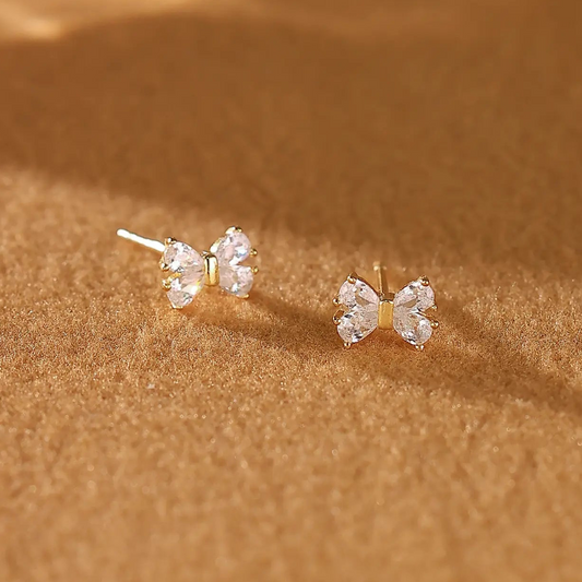 A pair of dainty 925 sterling silver gold bow stud earrings 